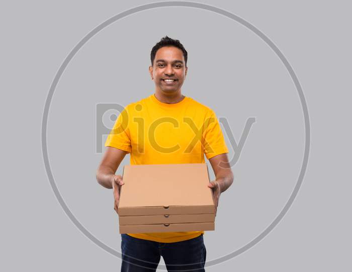 Delivery Man Three Pizza Box In Hands Isolated. Yellow Tshirt Indian Delivery Boy. Man With Pizza In Hands