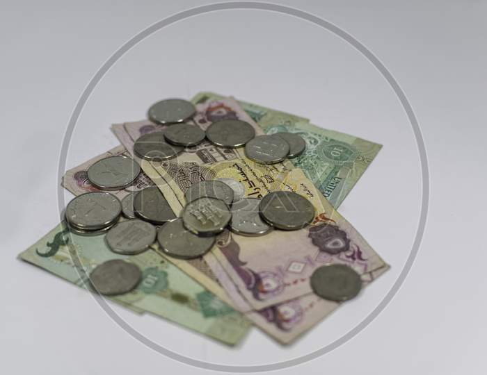 The Currency Of Uae, Dirhams Notes Of 10 And 5 Arranged Along With A Stack Of Coins.