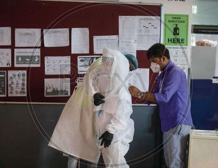 A health worker helps his colleague wear a PPE suit before entering the isolation wards at the Commonwealth Games Village Sports Complex which has been temporarily converted into a Coronavirus Care Centre in New Delhi on July 17, 2020