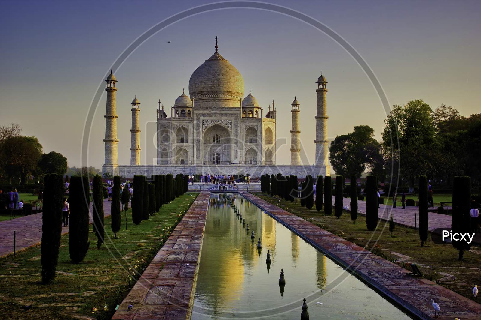 Agra, India - April 10,2014: Wide Angle Of Tajmahal With It'S Reflection In The Fountain Pond, One Of The Seven Wonder Partially Lit Under Dramatic Sunrise