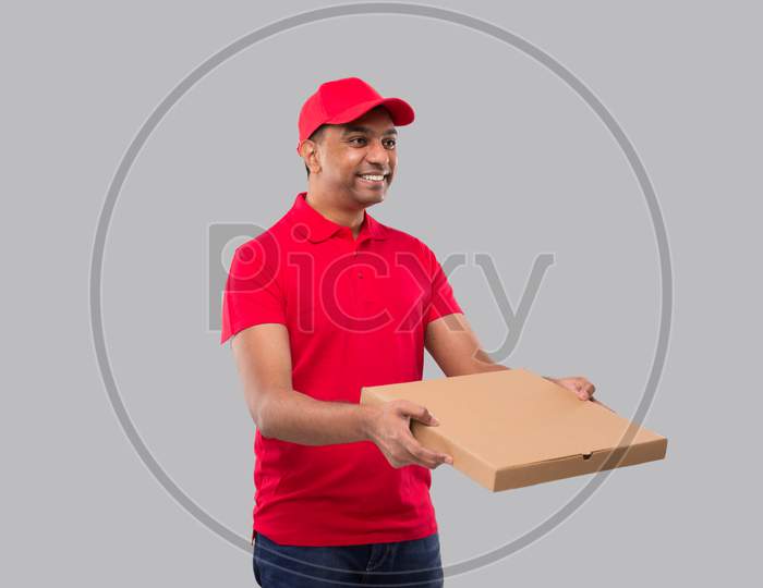 Delivery Man Pizza Box In Hands Watching Side Isolated. Red Tshirt Indian Delivery Boy.