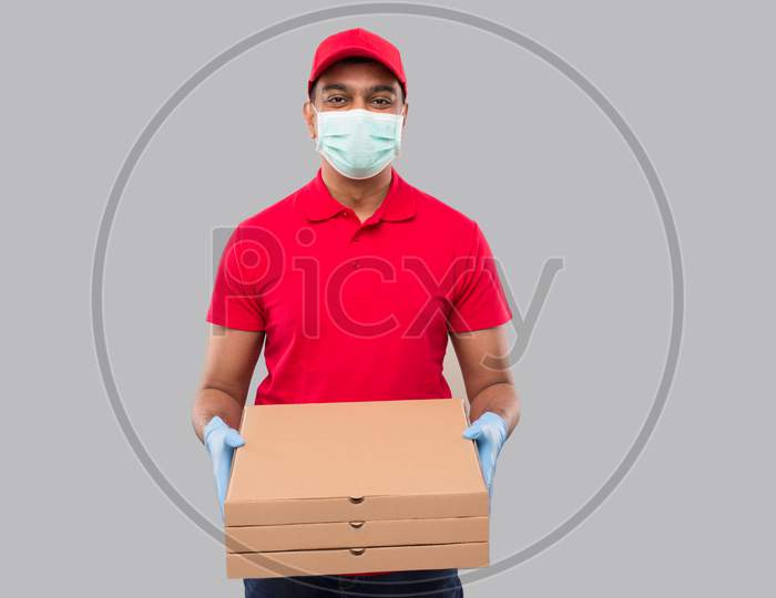 Delivery Man Three Pizza Box In Hands Wearing Medical Mask And Gloves Isolated. Red Tshirt Indian Delivery Boy.