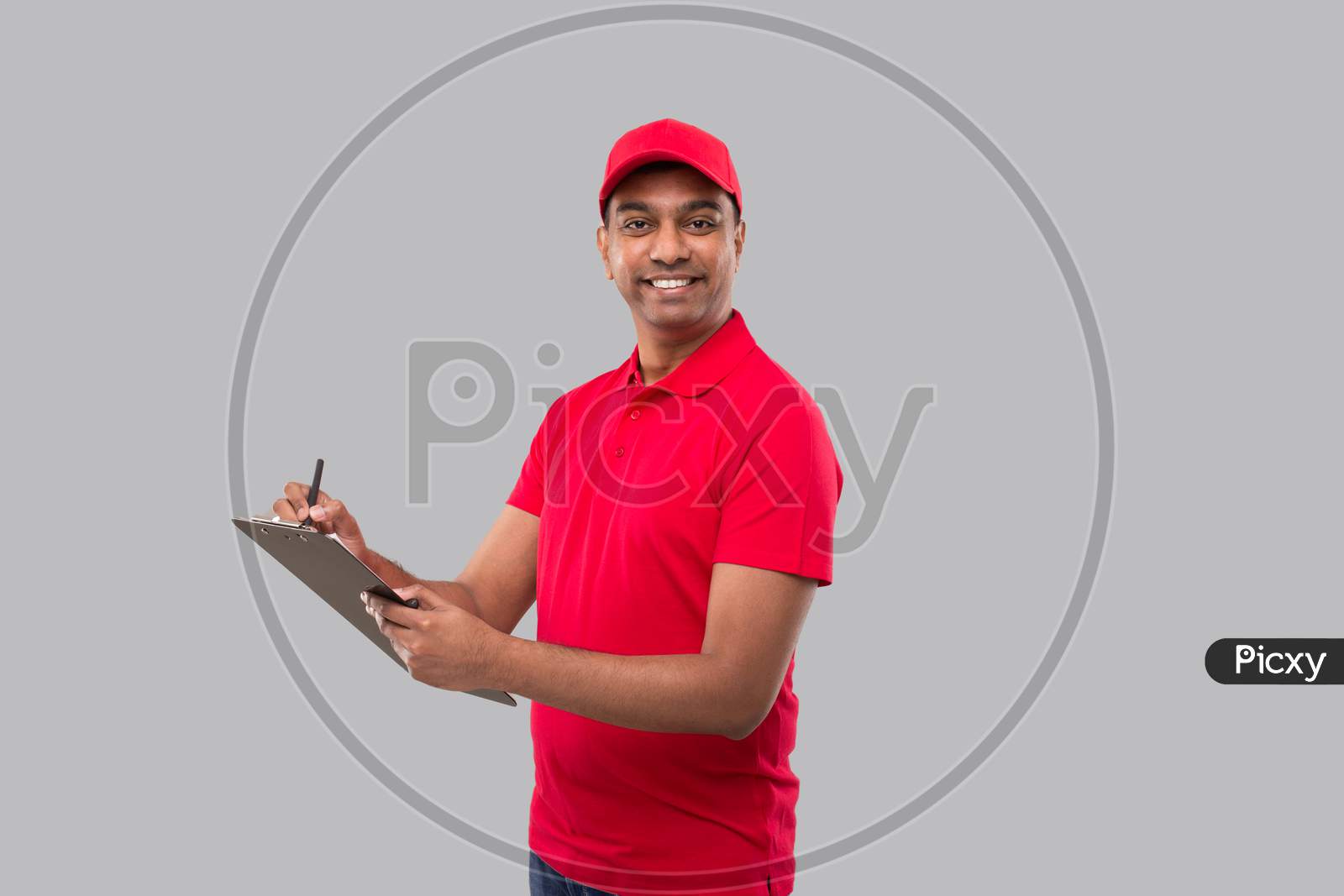 Delivery Man Writing In Clipboard Watching In Camera. Indian Delivery Boy Clipboard