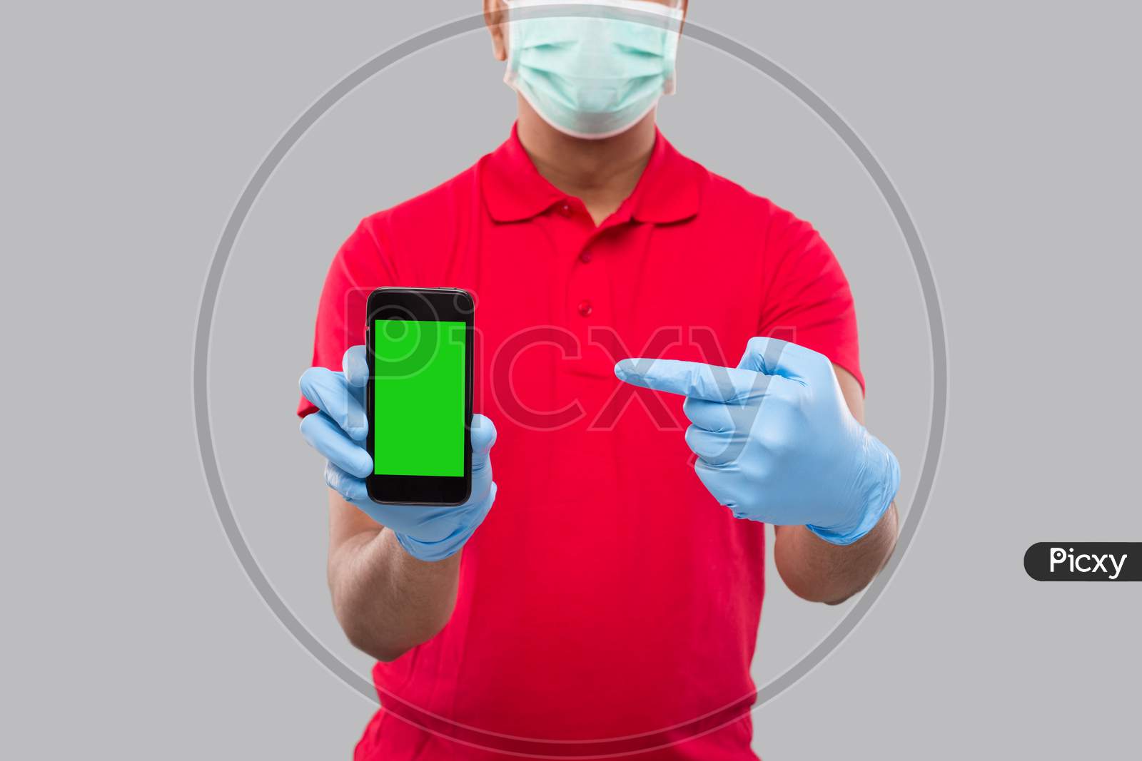 Indian Delivery Man Wearing Medical Mask And Gloves Pointing At Phone Showing Thumb Up. Home Delivery. Order Online Technology. Phone Green Screen Close Up