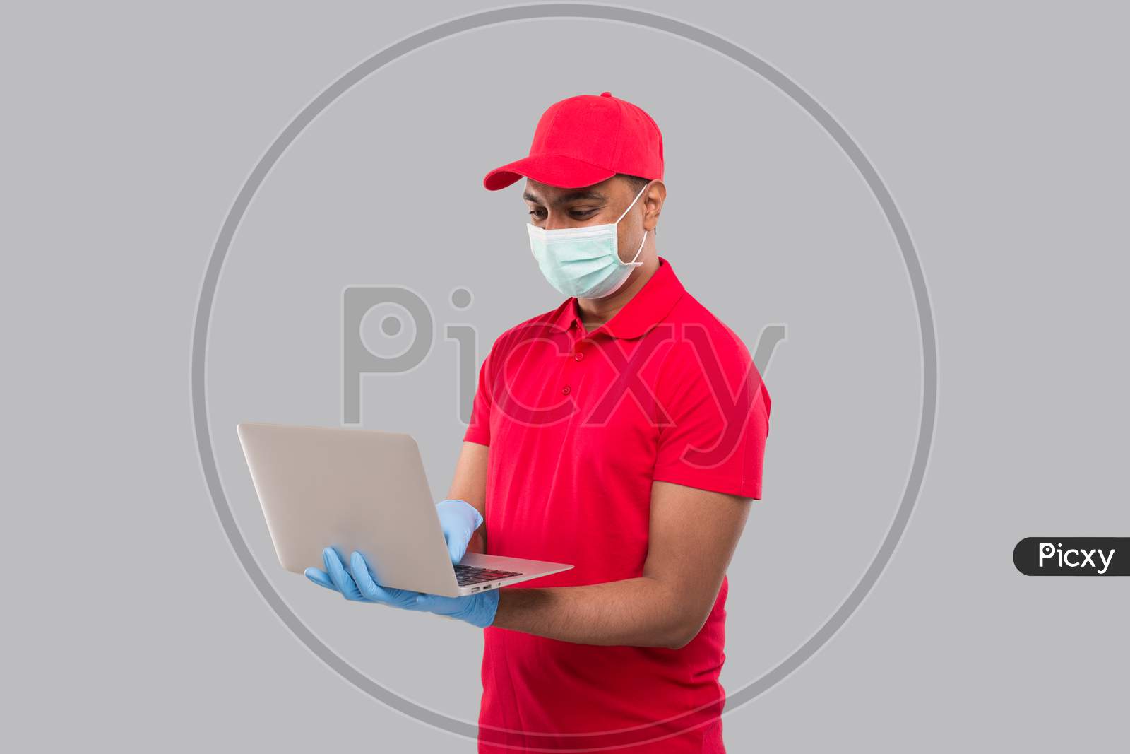 Delivery Man Using Laptop Green Screen Wearing Medical Mask And Gloves. Home Orders, Quarantine Delivery, Shopping Online, Freelance Worker Concept.