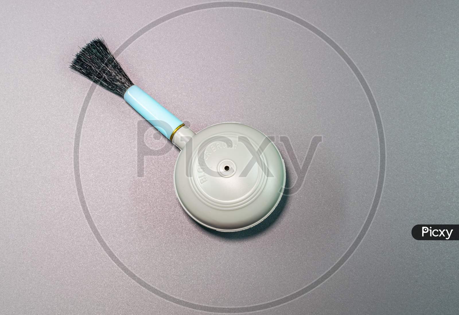 An Isolated View Of Hand Blower Brush In A Gray Background