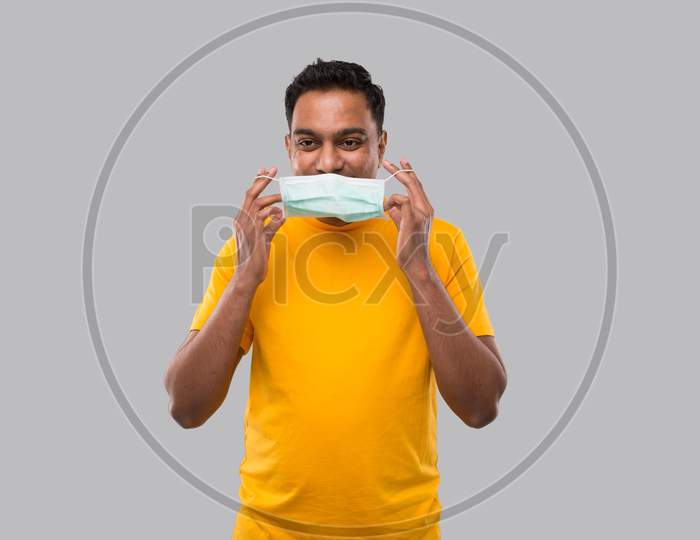 Indian Man Puts On Medical Mask In Yellow Tshirt Isolated