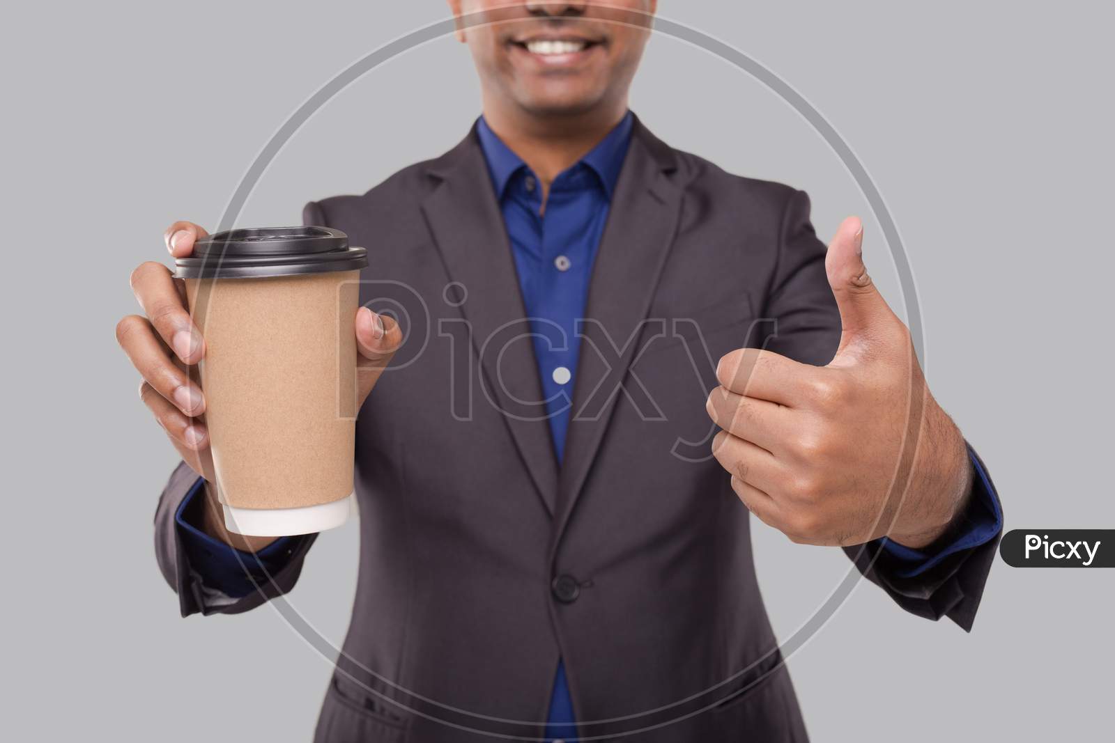 Businessman Holding Coffee To Go Cup Showing Thumb Up Isolated Close Up. Indian Business Man With Coffee Take Away Cup In Hands