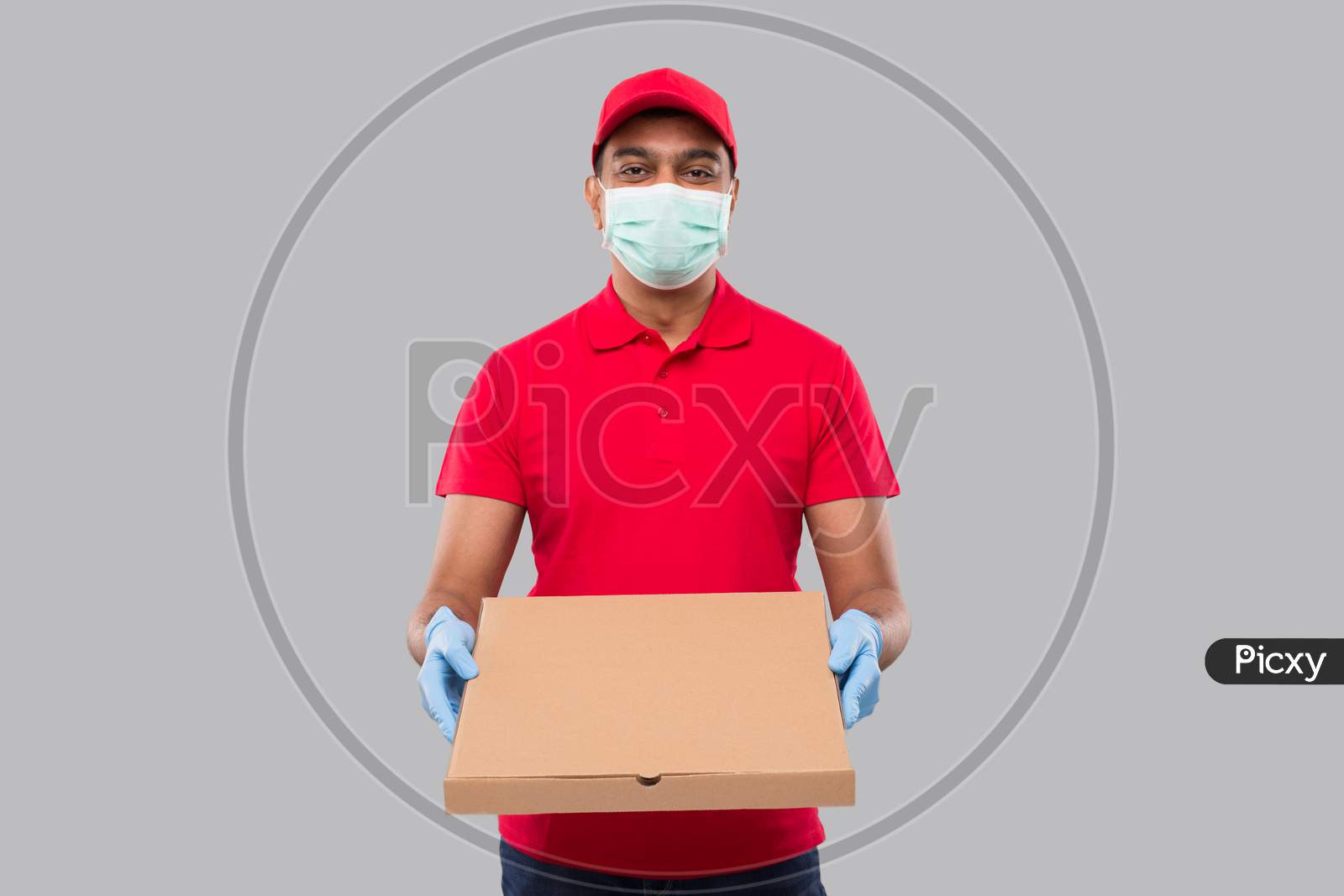 Delivery Man Pizza Box In Hands Wearing Medical Mask And Gloves Isolated. Red Tshirt Indian Delivery Boy.