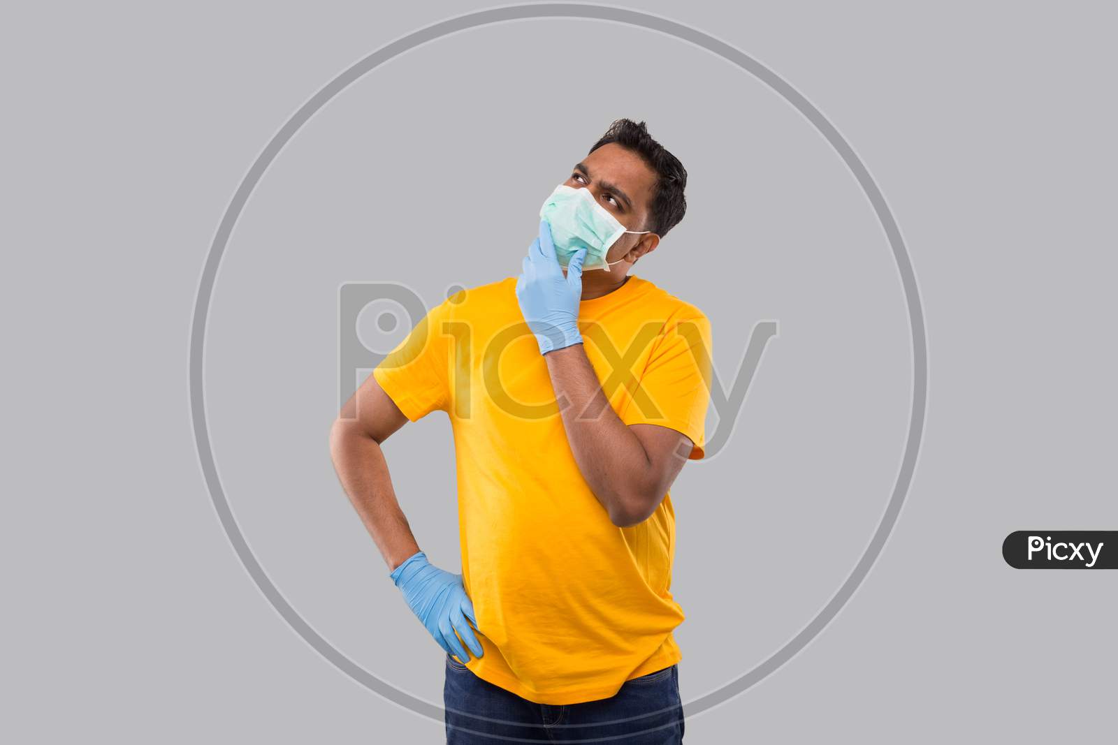 Indian Man Watching Up Wearing Medical Mask And Gloves Isolated. Man Thinking