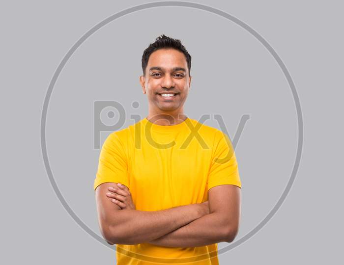 Indian Man Standing Hands Crossed Smiling In Yellow Tshirt Isolated