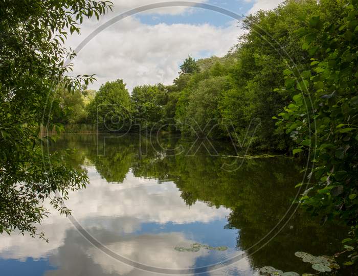 Lake Reflection Of Cloudy Blue Sky - Spring, Summers Season In England. Concept Of Tranquility And At One With Nature