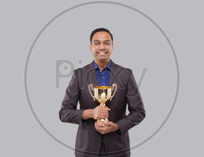 Businessman Holding Trophy. Indian Business Man Standing With Trophy In Hands