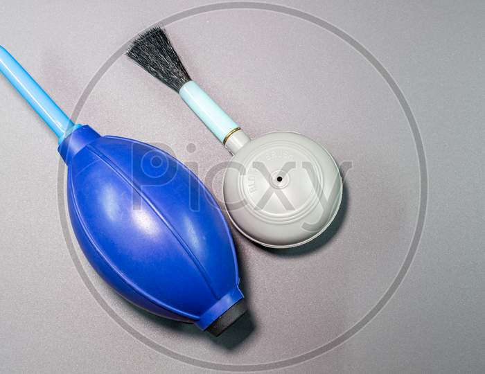 An Isolated View Of Hand Blower Brush And Blower In A Gray Background