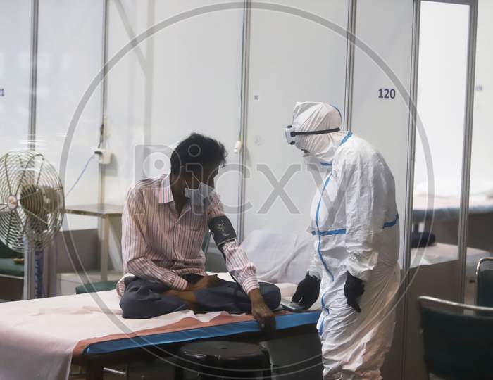 A health worker in a PPE suit interacts with a patient at Common Wealth Games Stadium which has been converted into a Coronavirus Care Centre in New Delhi on July 17, 2020