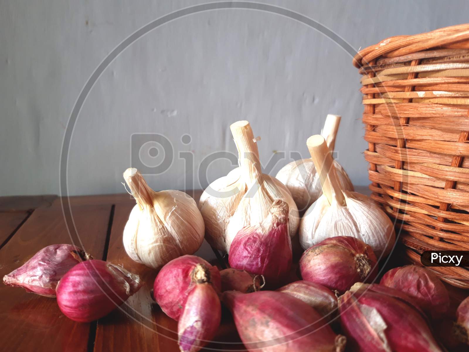 Garlic and onion are scattered on a wooden board
