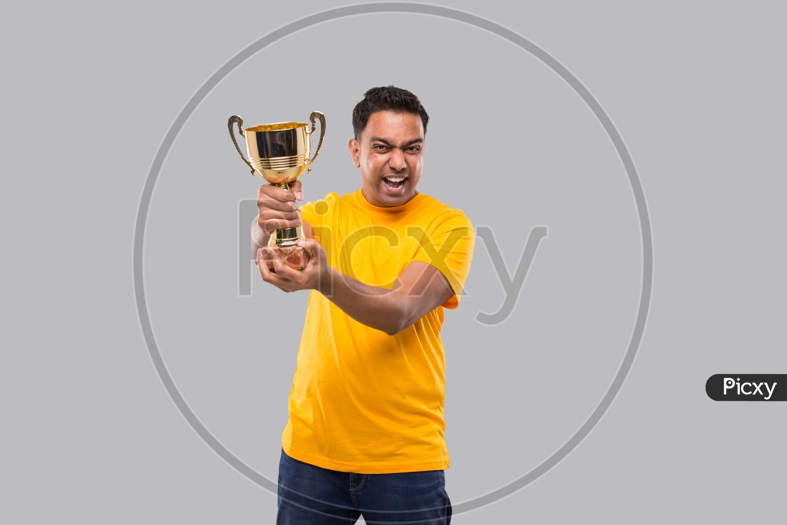Indian Man Very Happy And Excited, Raising Arms, Celebrating A Victory Or Success Holding Trophy. Winner Sign. Indian Man Isolated With Trophy In Hands