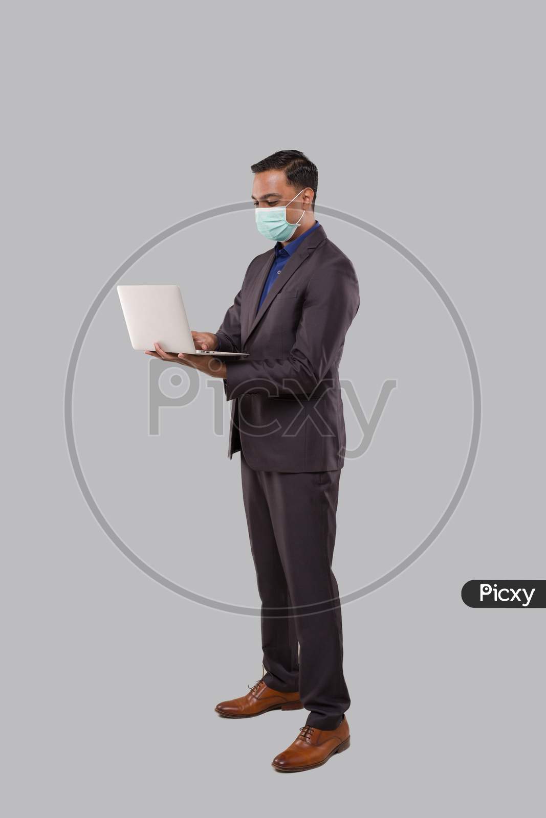 Businessman Using Laptop Green Screen Isolated Wearing Medical Mask. Indian Business Man With Laptop In Hands. Online Business Concept