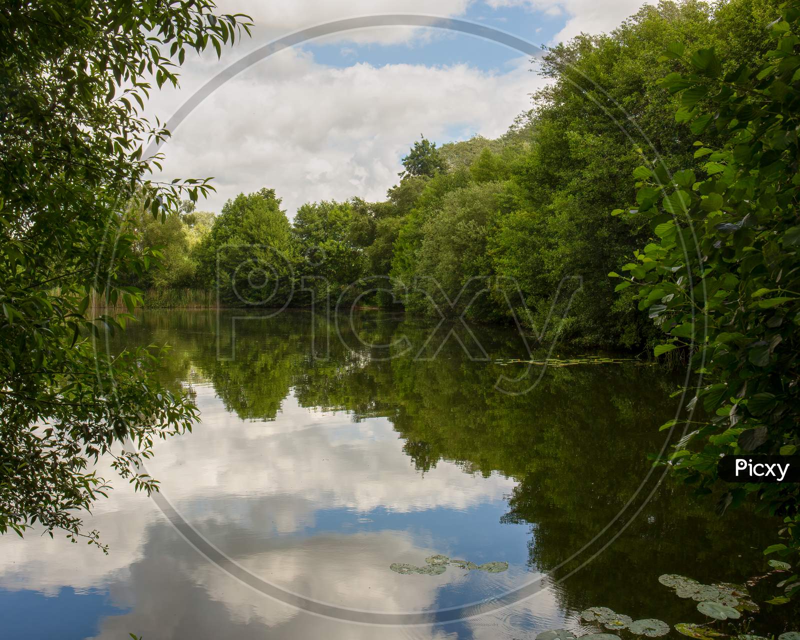 Lake Reflection Of Cloudy Blue Sky - Spring, Summers Season In England. Concept Of Tranquility And At One With Nature
