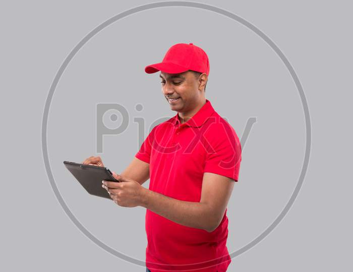 Delivery Man Using Tablet. Indian Delivery Boy With Tablet. Home Delivery Technology