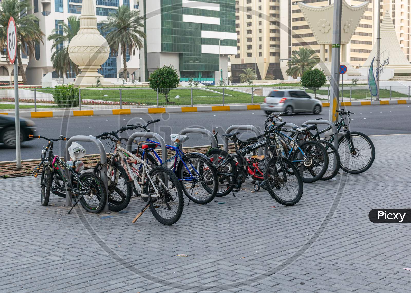 A Group Of Bycicles Parked In A Parking Space In Abu Dhabi Street.A Group Of Bicycles Parked In A Parking Space In Abu Dhabi Street.