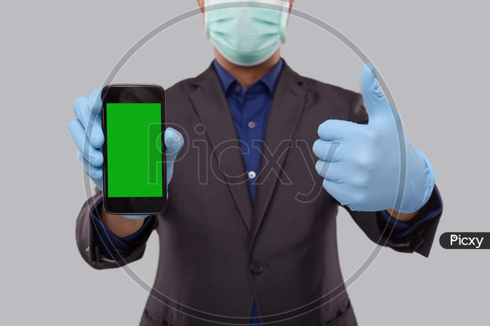Businessman Showing Phone And Thumb Up Wearing Medical Mask And Gloves. Indian Business Man Technology Business At Home. Phone Green Screen Isolated