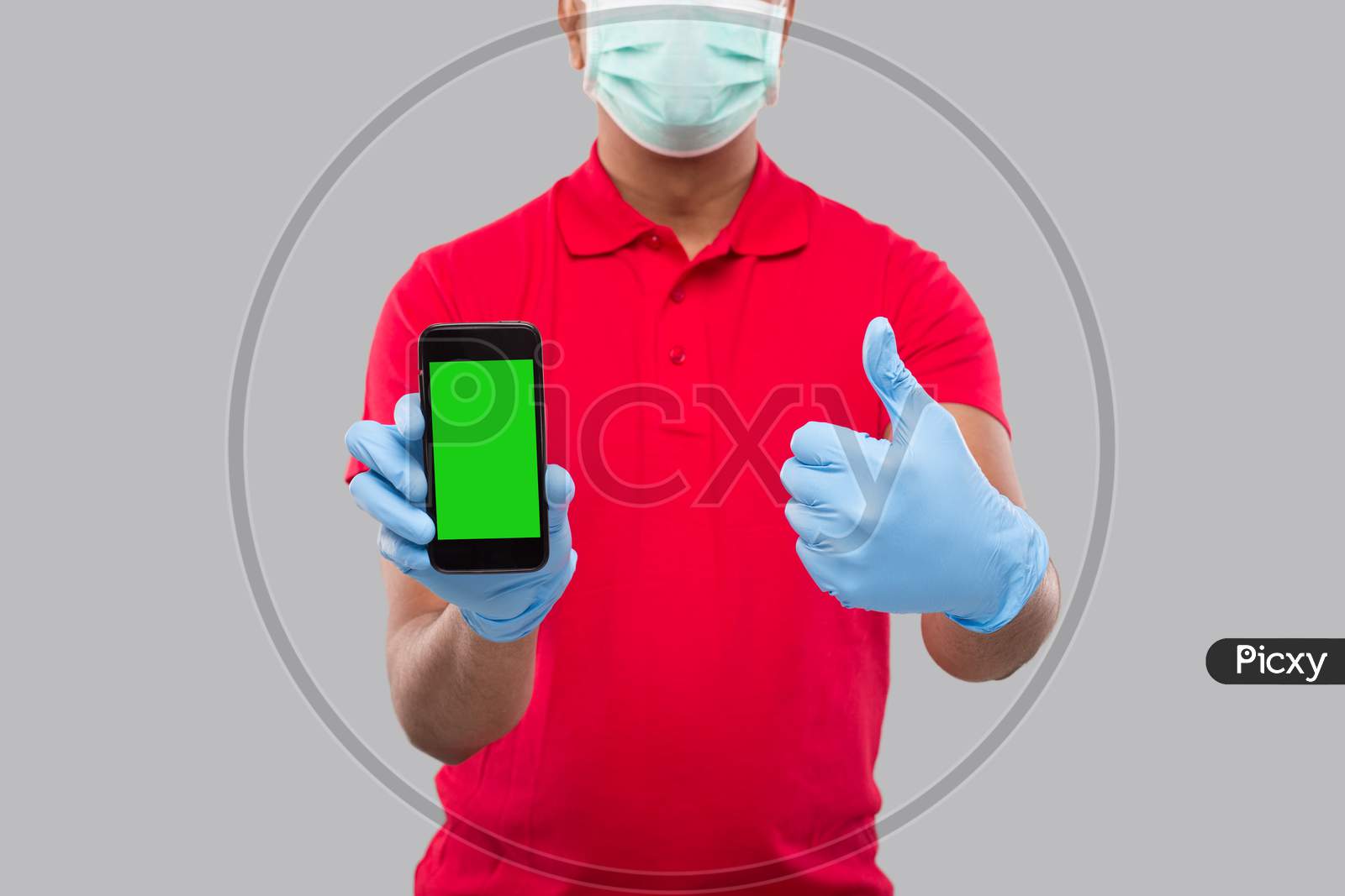 Indian Delivery Man Wearing Medical Mask And Gloves Holding Phone Showing Thumb Up. Home Delivery. Order Online Technology. Phone Green Screen Close Up