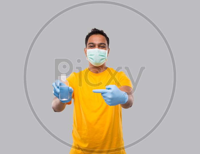 Indian Man Pointing At Hands Sanitizer Wearing Medical Mask And Gloves Isolated. Indian Man Holding Hand Antiseptic