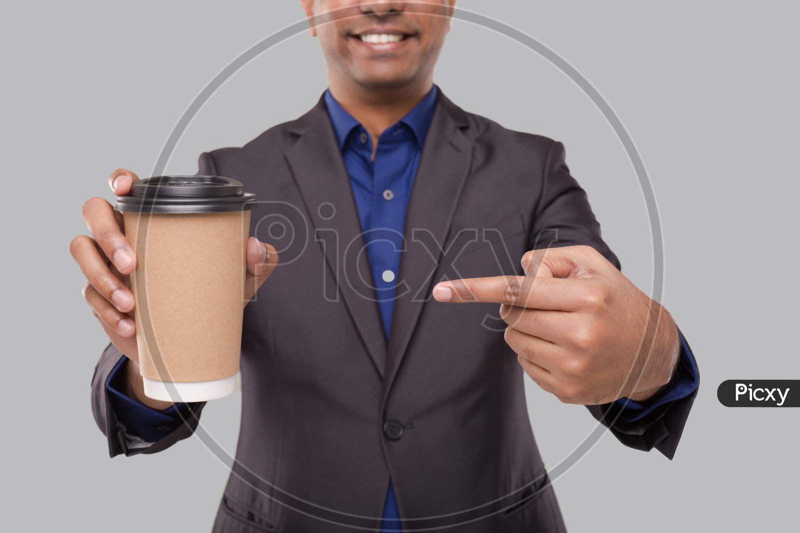 Businessman Pointing At Coffee To Go Cup Isolated Close Up. Indian Business Man With Coffee Take Away Cup In Hands