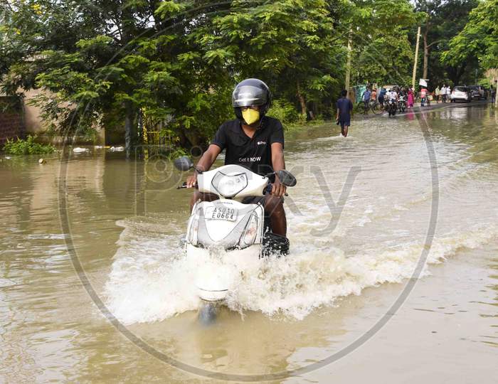 Bikers  move through a flood  water road