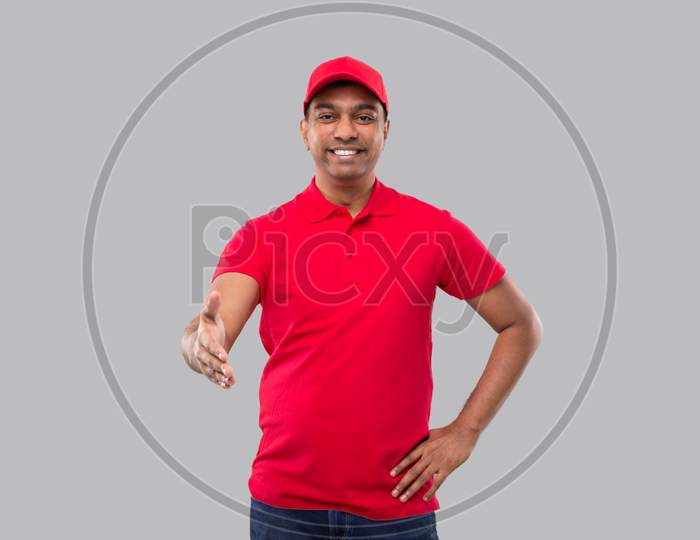 Indian Delivery Man Offering Hand To Shake. Greeting And Welcoming Gesture. Delivery Advertisement Concept. Delivery Man Hand Shake. Delivery Boy Isolated