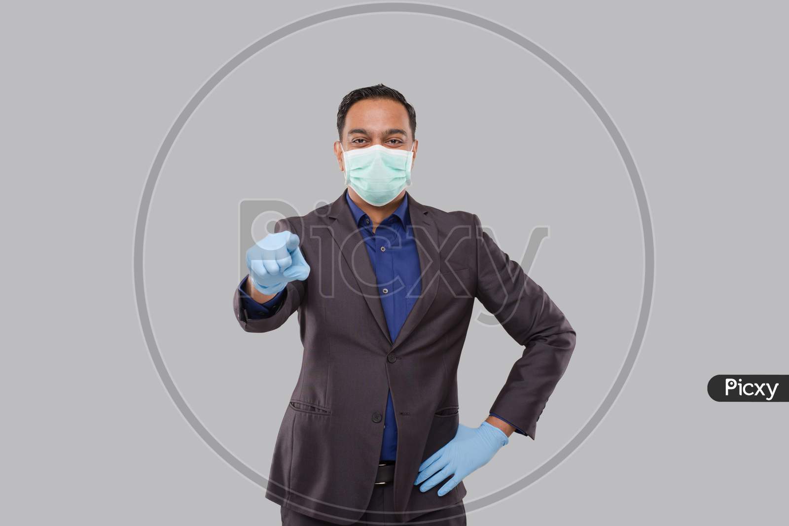 Businessman Pointing Front Watching In Camera Wearing Medical Mask And Gloves Isolated. Indian Business Man Pointing Front