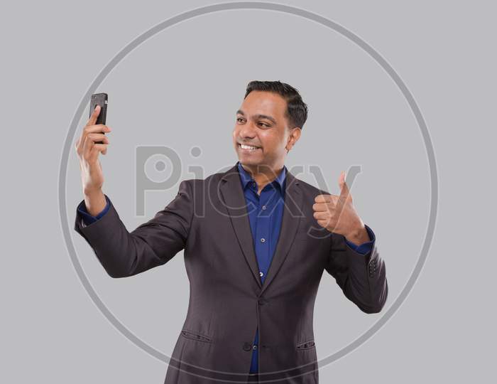 Businessman Having Video Call On Phone Showing Thumb Up Isolated. Indian Man Businessman Video Call. Business Online. Businessman Using Phone. Indian Business Man Standing Full Length