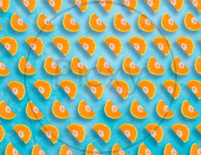 Fruit pattern of orange slices on blue background. Flat lay, top view. Food background