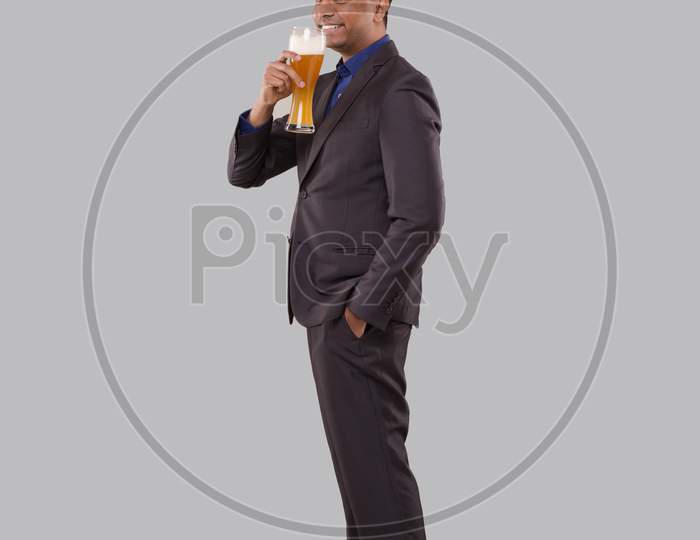Businessman Drinking Beer From Glass. Indian Business Man Standing Full Length With Beer In Hand