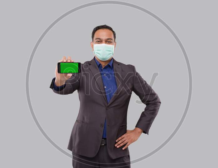 Businessman Showing Phone Holding Horizontal Wearing Medical Mask. Indian Business Man Technology Business At Home. Phone Green Screen Isolated