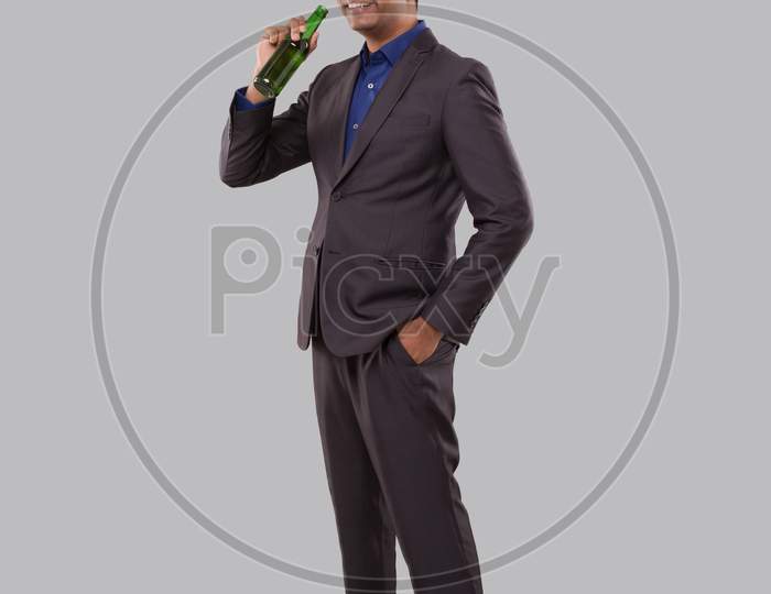 Businessman Drinking Beer From Bottle. Indian Businessman Standing Full Length.
