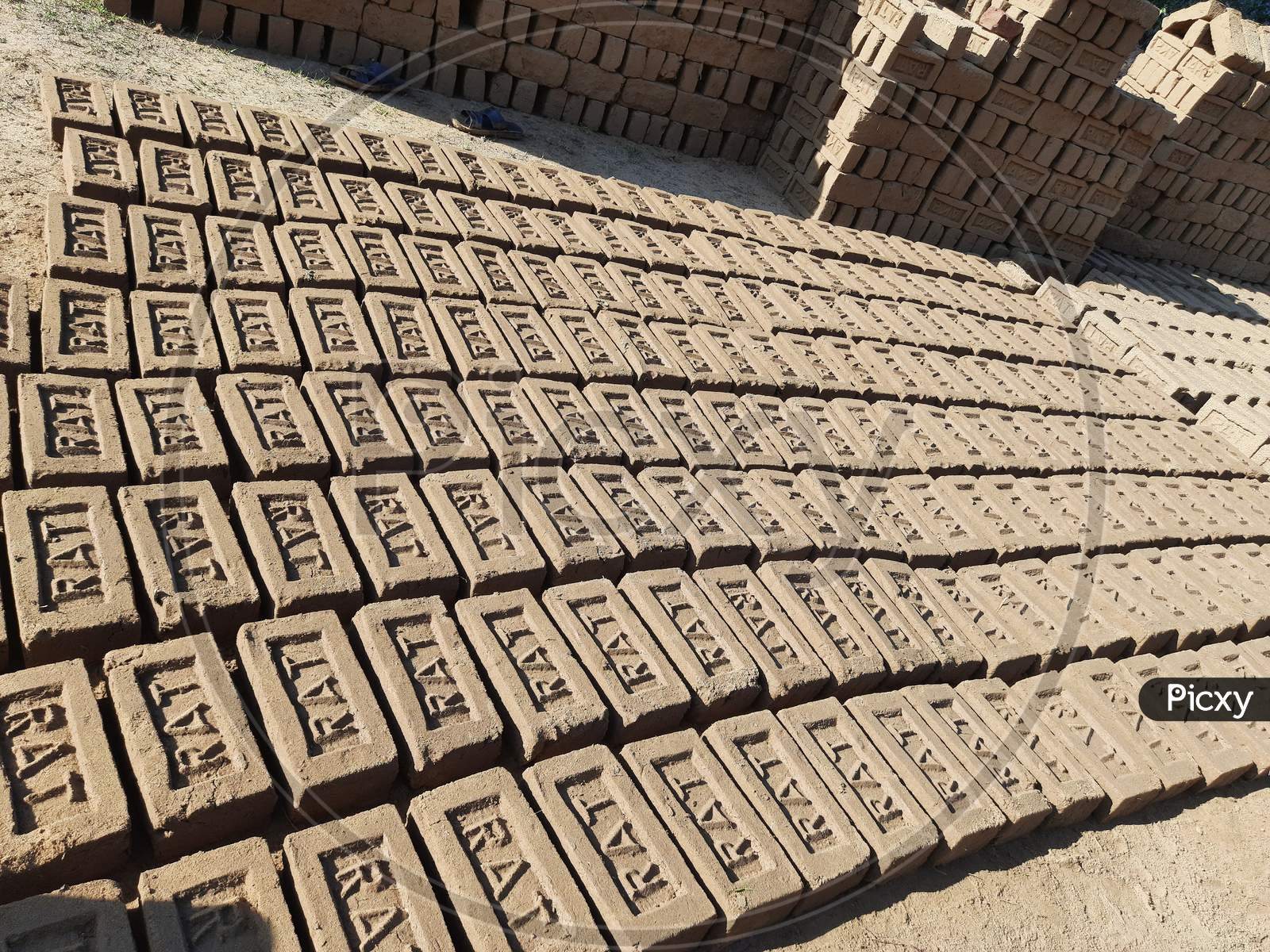 Raw brick laid out in stacks for drying.