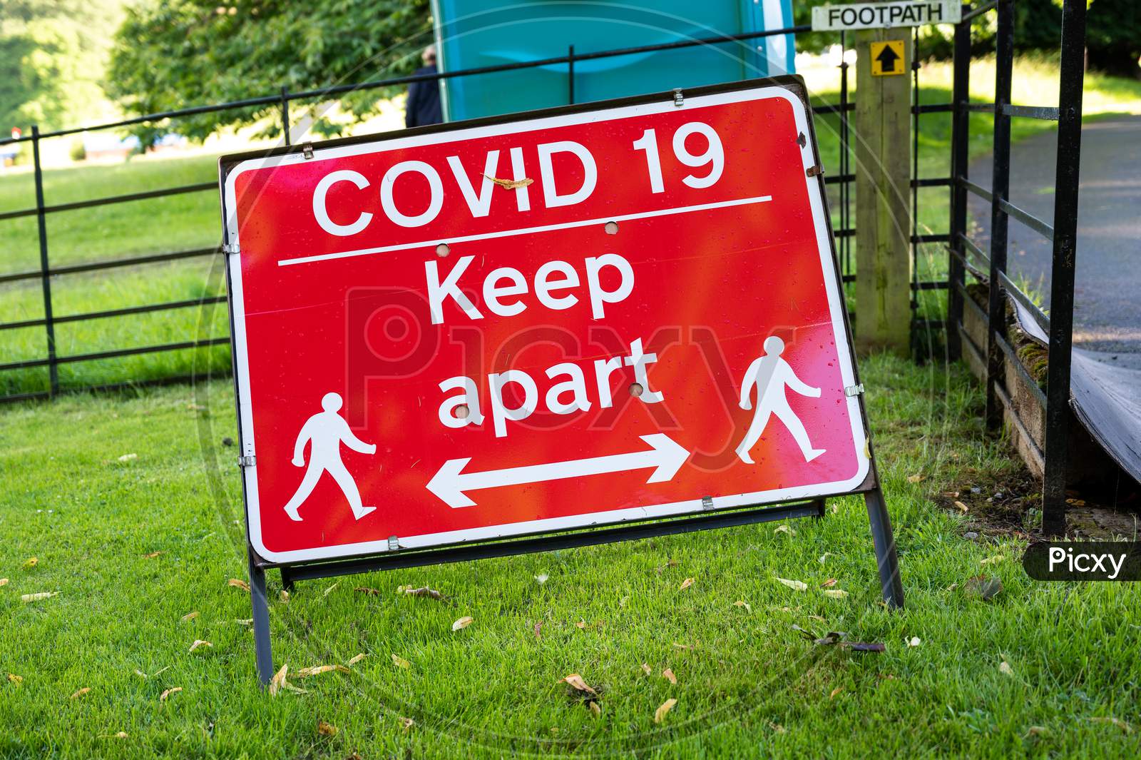 A Covid-19 Social Distancing Warning Sign At An Outdoor Event
