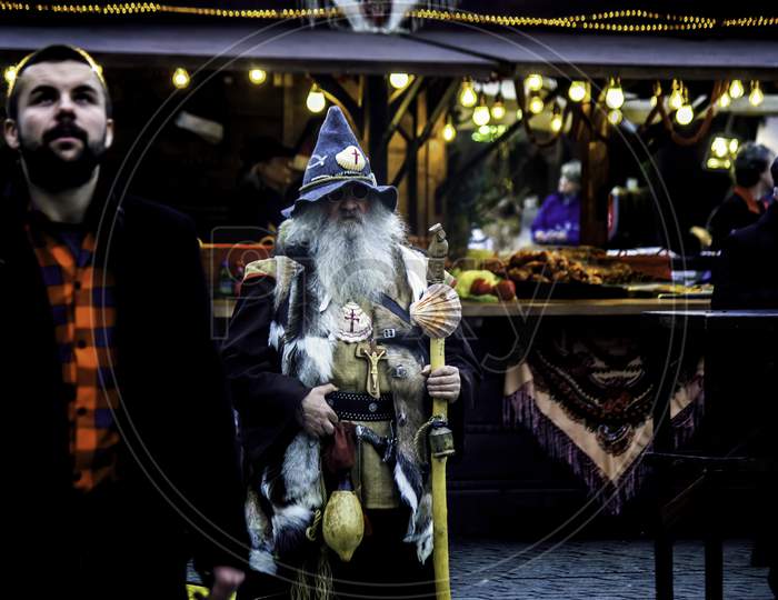 Krakow, Poland - December 08, 2014: Street Photography Of A Man Dressed Up Unique In Main Square Center Around Souvenir Shops