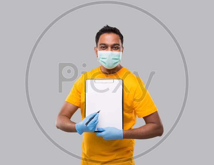 Indian Man Pointing At Clipboard Wearing Medical Mask And Gloves Watching In Camera. Indian Delivery Boy Clipboard