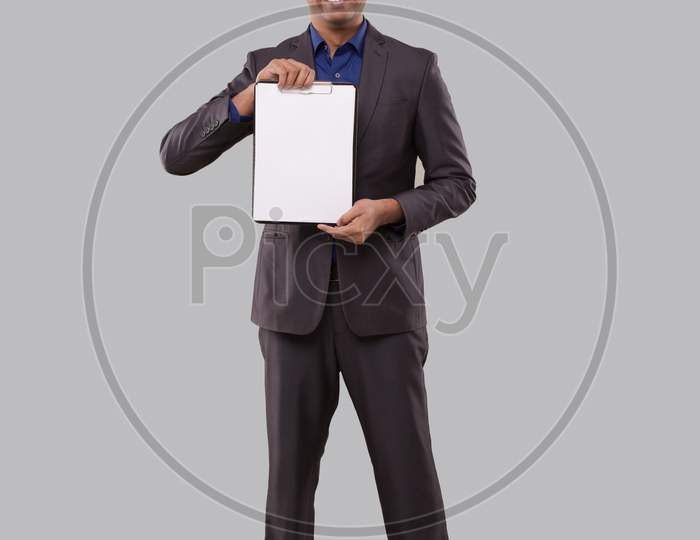 Businessman Holding Clipboard Watching In Camera Isolated. Indian Business Man Standing Full Length With Clipboard In Hands
