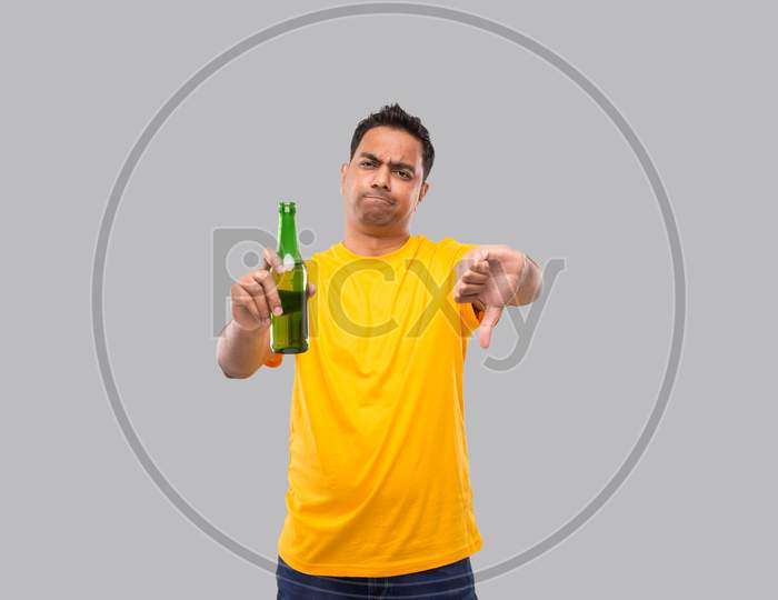 Indian Man Holding At Beer From Beer Bottle Showing Thumb Down Isolated.