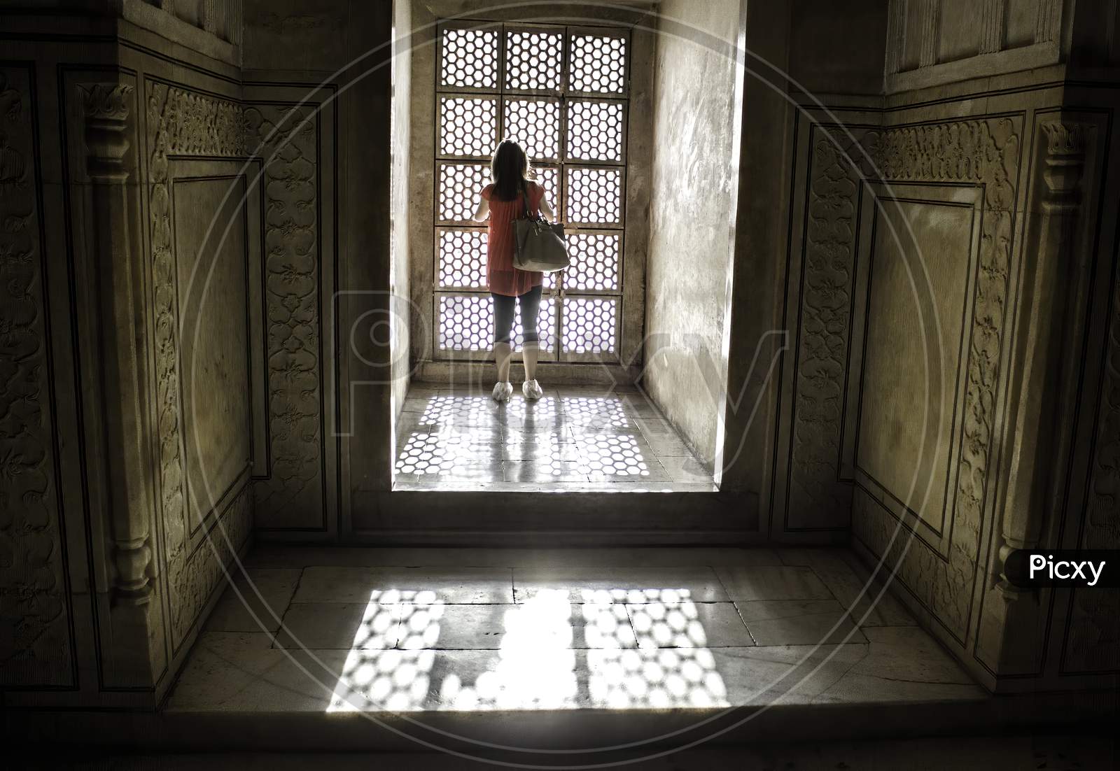Agra, India - April 10,2014: A Female Tourist Wearing Plastic Bag Shoes Inside Tajmahal Dome And Sun Rays Coming Through Windows