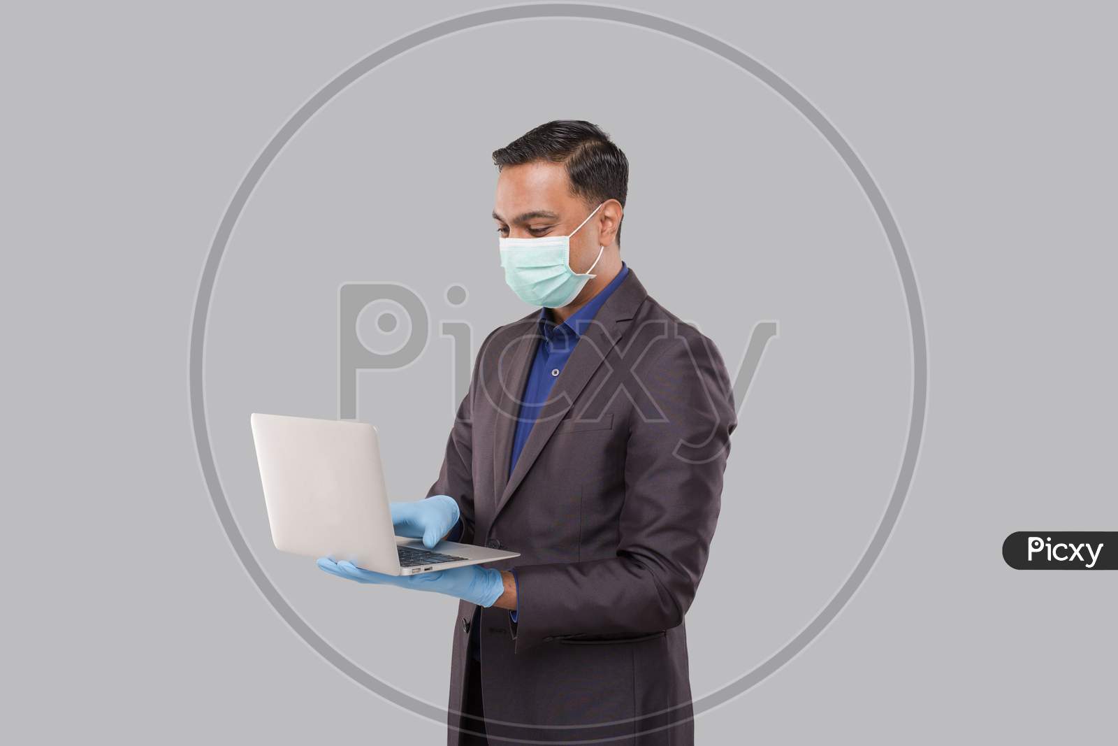 Businessman Using Laptop Green Screen Isolated Wearing Medical Mask And Gloves. Indian Business Man With Laptop In Hands. Online Business Concept