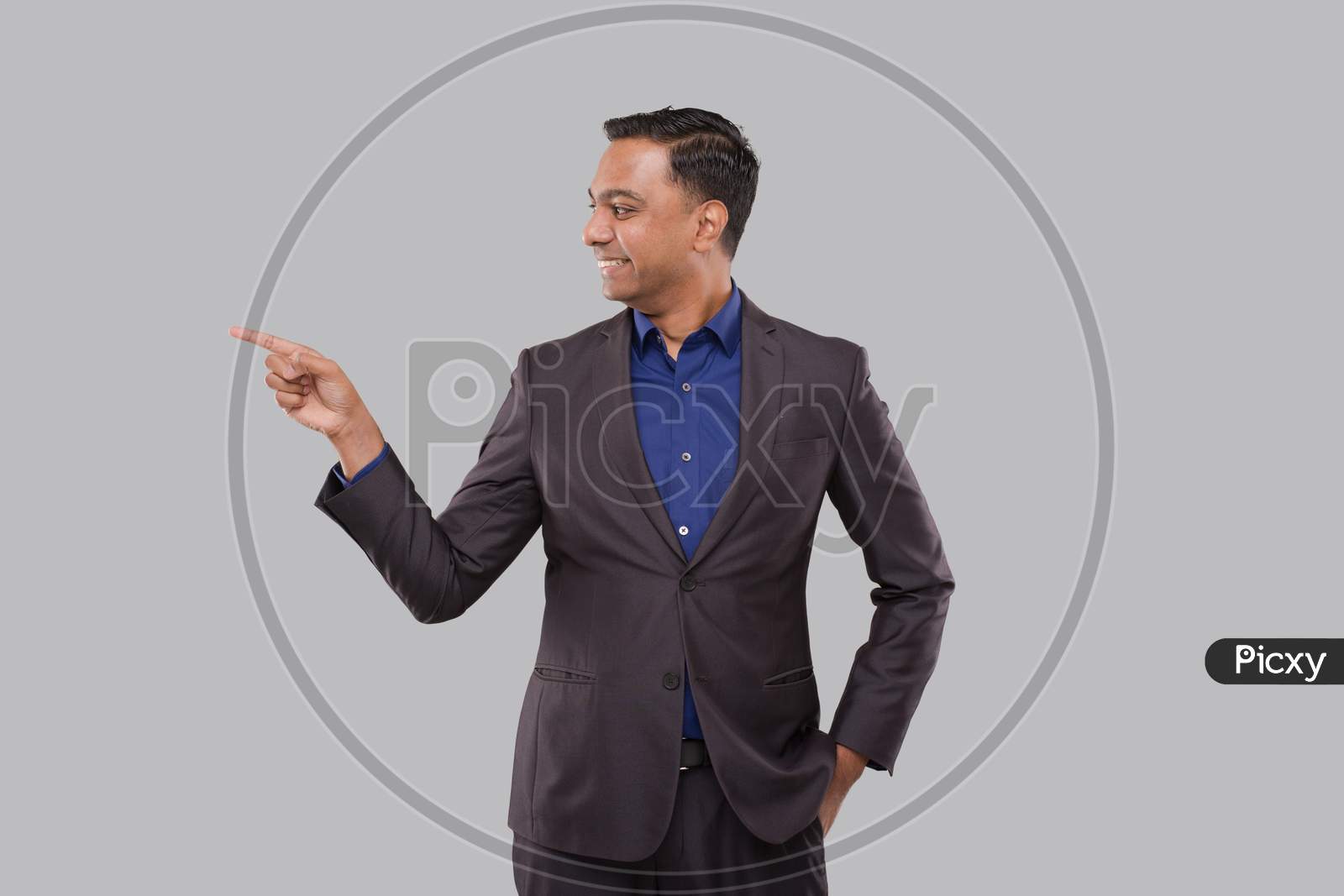 Businessman Pointing To Side Isolated. Indian Man Standing