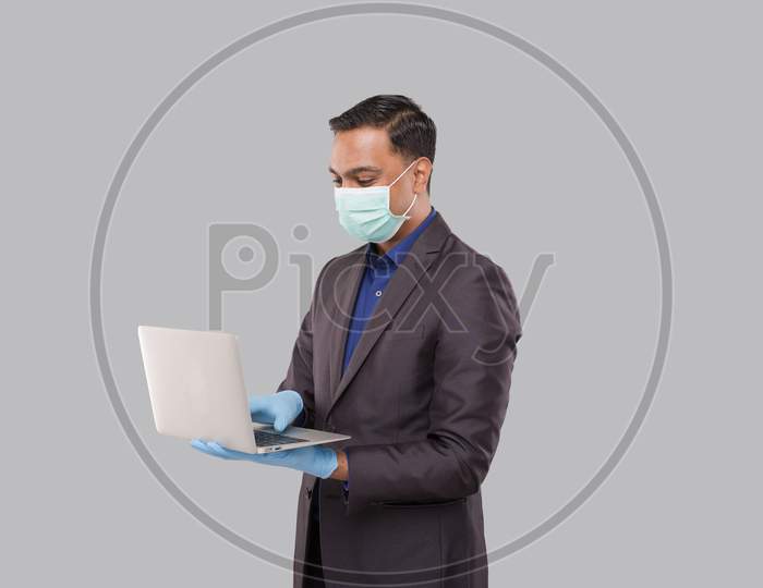 Businessman Using Laptop Green Screen Isolated Wearing Medical Mask And Gloves. Indian Business Man With Laptop In Hands. Online Business Concept