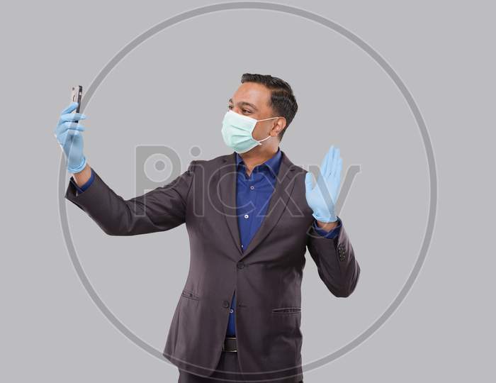 Businessman Having Video Call On Phone Wearing Medical Mask And Gloves Isolated. Indian Man Businessman Video Call. Business Online. Businessman Using Phone. Indian Business Man