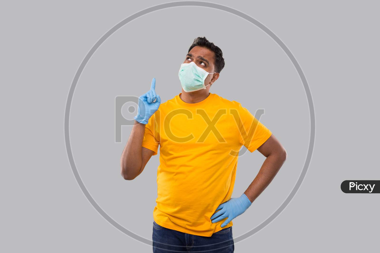 Indian Man Pointing Up Wearing Medical Mask And Gloves Isolated. Man Thinking