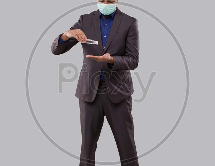 Businessman Wearing Medical Mask Using Hand Sanitizer. Indian Business Man Using Hands Antiseptic